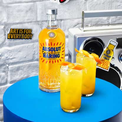 Two Absolut Haring Collins cocktails next to a bottle of Absolut Haring.