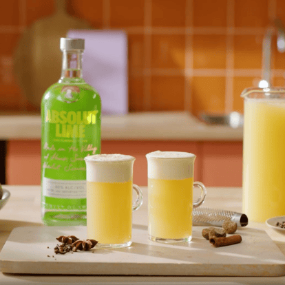 Two Hot Lime Mule drinks next to a bottle of Absolut Lime.