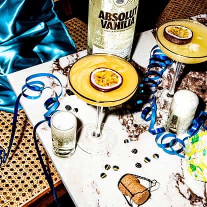 Pornstar Martini cocktails with two Champagne shots, Absolut Vanilia, a champagne cork, and party streamers.